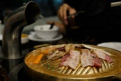 Griglia della carne di maiale sulla pentola dell'ottone del BBQ immagini stock libere da diritti Griglia della carne di maiale sulla pentola dell'ottone del BBQ immagini stock libere da diritti