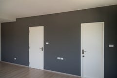 Grijze muurdecoratie met witte gesloten deur stock afbeeldingen Grijze muurdecoratie met witte gesloten deur stock afbeeldingen