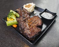 Grilled Black Angus Steak Ribeye on black plate stock photos Grilled Black Angus Steak Ribeye on black plate stock photos
