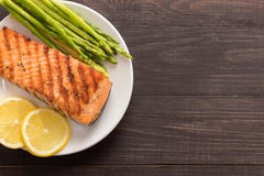 Grilled salmon with lemon, asparagus on the wooden background royalty free stock photography Grilled salmon with lemon, asparagus on the wooden background royalty free stock photography
