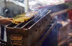 Griller satay de porc sur le fourneau ou le style thaïlandais le rôti de porc au marché images libres de droits Griller satay de porc sur le fourneau ou le style thaïlandais le rôti de porc au marché images libres de droits