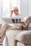 Petite elderly lady adjusting glasses while reading newspaper royalty free stock photo Petite elderly lady adjusting glasses while reading newspaper royalty free stock photo