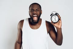 Gritos afro-americanos irritados do homem que guardam o alarme fotografia de stock Gritos afro-americanos irritados do homem que guardam o alarme fotografia de stock