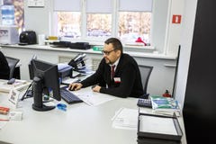 GRODNO, BELARUS - AUGUST 2017: employees to answer the call in the store at work at the computer in modern shop stock photo GRODNO, BELARUS - AUGUST 2017: employees to answer the call in the store at work at the computer in modern shop stock photo