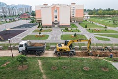 GRODNO VITRYSSLAND - SEPTEMBER 2018: Grävskopan gräver en grop och laddar sanden på en dumper arkivfoton GRODNO VITRYSSLAND - SEPTEMBER 2018: Grävskopan gräver en grop och laddar sanden på en dumper arkivfoton