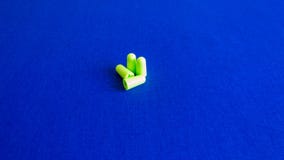 Groene oordopjes op blauwe achtergrondafbeelding stock fotografie Groene oordopjes op blauwe achtergrondafbeelding stock fotografie