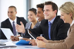 Groep Bedrijfsmensen die aan Collega luisteren die Bureauvergadering richten stock afbeeldingen Groep Bedrijfsmensen die aan Collega luisteren die Bureauvergadering richten stock afbeeldingen