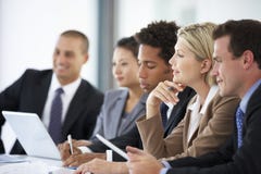 Groep Bedrijfsmensen die aan Collega luisteren die Bureauvergadering richten stock afbeeldingen Groep Bedrijfsmensen die aan Collega luisteren die Bureauvergadering richten stock afbeeldingen