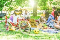 Groep heel wat mensen die een smakelijke picknick hebben die en rode wijn in een park eet drinkt openlucht stock afbeelding Groep heel wat mensen die een smakelijke picknick hebben die en rode wijn in een park eet drinkt openlucht stock afbeelding