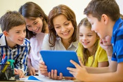 Groep jonge geitjes met leraar en tabletpc op school