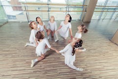 Groep van zeven kleine ballerina's die op de vloer zitten Zij zijn goede vriend en verbazende dansuitvoerders royalty-vrije stock afbeelding Groep van zeven kleine ballerina's die op de vloer zitten Zij zijn goede vriend en verbazende dansuitvoerders royalty-vrije stock afbeelding