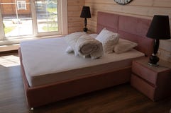 Groot tweepersoonsbed met twee witte hoofdkussens en witte deken in het luxehotel stock fotografie Groot tweepersoonsbed met twee witte hoofdkussens en witte deken in het luxehotel stock fotografie