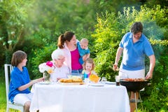 Grote familie die vlees voor lunch roosteren royalty-vrije stock afbeeldingen Grote familie die vlees voor lunch roosteren royalty-vrije stock afbeeldingen