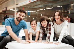Grote gelukkige familie die orthopedische matras in winkel van meubilair testen Controlezachtheid van matras stock afbeeldingen Grote gelukkige familie die orthopedische matras in winkel van meubilair testen Controlezachtheid van matras stock afbeeldingen