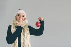 Grote rode Kerstmisbal in handen bij de vrouwen Het meisje is gekleed in sweater, Kerstmishoed en het schot van de sjaalstudio Stock Afbeeldingen Grote rode Kerstmisbal in handen bij de vrouwen Het meisje is gekleed in sweater, Kerstmishoed en het schot van de sjaalstudio Stock Afbeeldingen