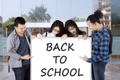 Students pointing on whiteboard saying back to school Royalty Free Stock Images Students pointing on whiteboard saying back to school Royalty Free Stock Images