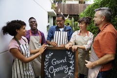 Group of friends with grand opening board together royalty free stock photography Group of friends with grand opening board together royalty free stock photography