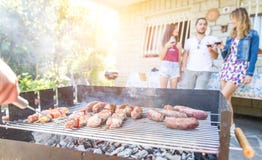 Group of friends making a barbecue in the backyard garden royalty free stock photography Group of friends making a barbecue in the backyard garden royalty free stock photography
