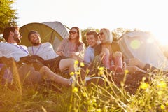Group Of Friends Relaxing Outside Tents On Camping Holiday royalty free stock photo Group Of Friends Relaxing Outside Tents On Camping Holiday royalty free stock photo