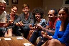 Group of friends sitting around a table at house party royalty free stock photography Group of friends sitting around a table at house party royalty free stock photography