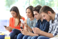 Group of friends using their smart phones at home stock images Group of friends using their smart phones at home stock images