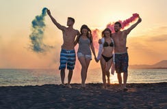 Group of happy people walking on beautiful beach in summer sunset stock image Group of happy people walking on beautiful beach in summer sunset stock image