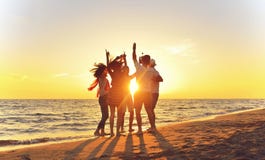 Group of happy young people dancing at the beach on beautiful summer sunset stock image Group of happy young people dancing at the beach on beautiful summer sunset stock image