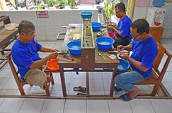 A group of male silversmith washing, cleaning and putting final touch on the pure silver ornaments