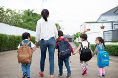 Group of preschool student and teacher holding hands and walking to home. Mom bring her children go to school together. Back to stock photo Group of preschool student and teacher holding hands and walking to home. Mom bring her children go to school together. Back to stock photo