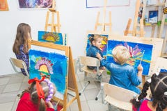 A group of preschool students and young teacher in drawing class paint in gouache. mixed race schoolgirl afroamerican stock images A group of preschool students and young teacher in drawing class paint in gouache. mixed race schoolgirl afroamerican stock images