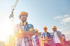 Group of smiling builders in hardhats outdoors stock image Group of smiling builders in hardhats outdoors stock image