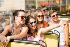 Group of smiling friends traveling by tour bus
