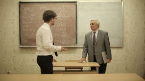 Group of students in a classroom, listening as their teacher holds a lecture stock footage Group of students in a classroom, listening as their teacher holds a lecture stock footage