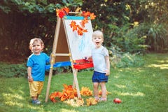 Group of two white Caucasian toddler children kids boy and girl standing outside in summer autumn park by drawing easel Royalty Free Stock Images Group of two white Caucasian toddler children kids boy and girl standing outside in summer autumn park by drawing easel Royalty Free Stock Images