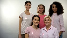 Group of women in pink shirts with breast cancer ribbons looking into camera stock image Group of women in pink shirts with breast cancer ribbons looking into camera stock image