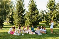 Group of young womans sit on picnic blanket in green summer park. Summer weekends royalty free stock photography Group of young womans sit on picnic blanket in green summer park. Summer weekends royalty free stock photography