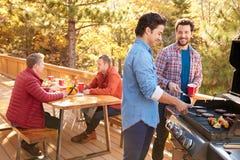 Groupe d'amis masculins gais appréciant le barbecue ensemble image libre de droits Groupe d'amis masculins gais appréciant le barbecue ensemble image libre de droits