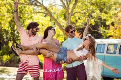 Groupe d'amis portant des femmes en parc photographie stock libre de droits Groupe d'amis portant des femmes en parc photographie stock libre de droits