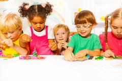 Groupe d'enfants dans le jeu de jardin d'enfants avec de la pâte à modeler photographie stock libre de droits Groupe d'enfants dans le jeu de jardin d'enfants avec de la pâte à modeler photographie stock libre de droits