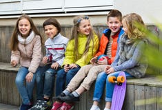 Groupe d'enfants s'asseyant sur le banc image stock Groupe d'enfants s'asseyant sur le banc image stock