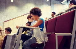 Groupe d'?tudiants avec des carnets ? la salle de conf?rences images libres de droits Groupe d'?tudiants avec des carnets ? la salle de conf?rences images libres de droits