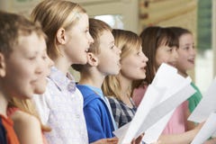 Groupe d'écoliers chantant dans le choeur d'école image stock Groupe d'écoliers chantant dans le choeur d'école image stock