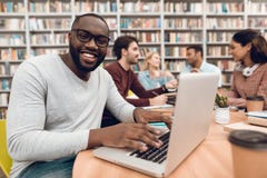 Groupe d'étudiants multiculturels ethniques dans la bibliothèque Type noir sur l'ordinateur portable images libres de droits Groupe d'étudiants multiculturels ethniques dans la bibliothèque Type noir sur l'ordinateur portable images libres de droits