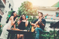 Groupe de jeunes asiatiques heureux tout en appréciant à la maison la partie et images stock Groupe de jeunes asiatiques heureux tout en appréciant à la maison la partie et images stock