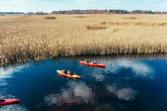 Groupe de personnes dans des kayaks parmi des roseaux sur la rivi?re d'automne image stock Groupe de personnes dans des kayaks parmi des roseaux sur la rivi?re d'automne image stock