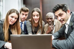 Groupe de personnes occupées multi-ethniques regardant un ordinateur portable image libre de droits Groupe de personnes occupées multi-ethniques regardant un ordinateur portable image libre de droits