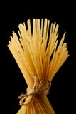 Groupe de spaghetti attachés avec la corde jaune italien de pâtes Longs spaghetti D'isolement sur un fond noir image stock Groupe de spaghetti attachés avec la corde jaune italien de pâtes Longs spaghetti D'isolement sur un fond noir image stock
