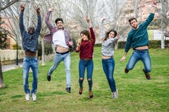 Groupe des jeunes sautant ensemble dehors photos libres de droits Groupe des jeunes sautant ensemble dehors photos libres de droits