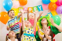 Groupe gai d'enfants avec le clown célébrant l'anniversaire image stock Groupe gai d'enfants avec le clown célébrant l'anniversaire image stock