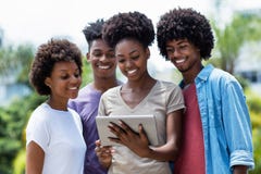 Groupe riant d'étudiants d'afro-américain avec le comprimé numérique photo stock Groupe riant d'étudiants d'afro-américain avec le comprimé numérique photo stock